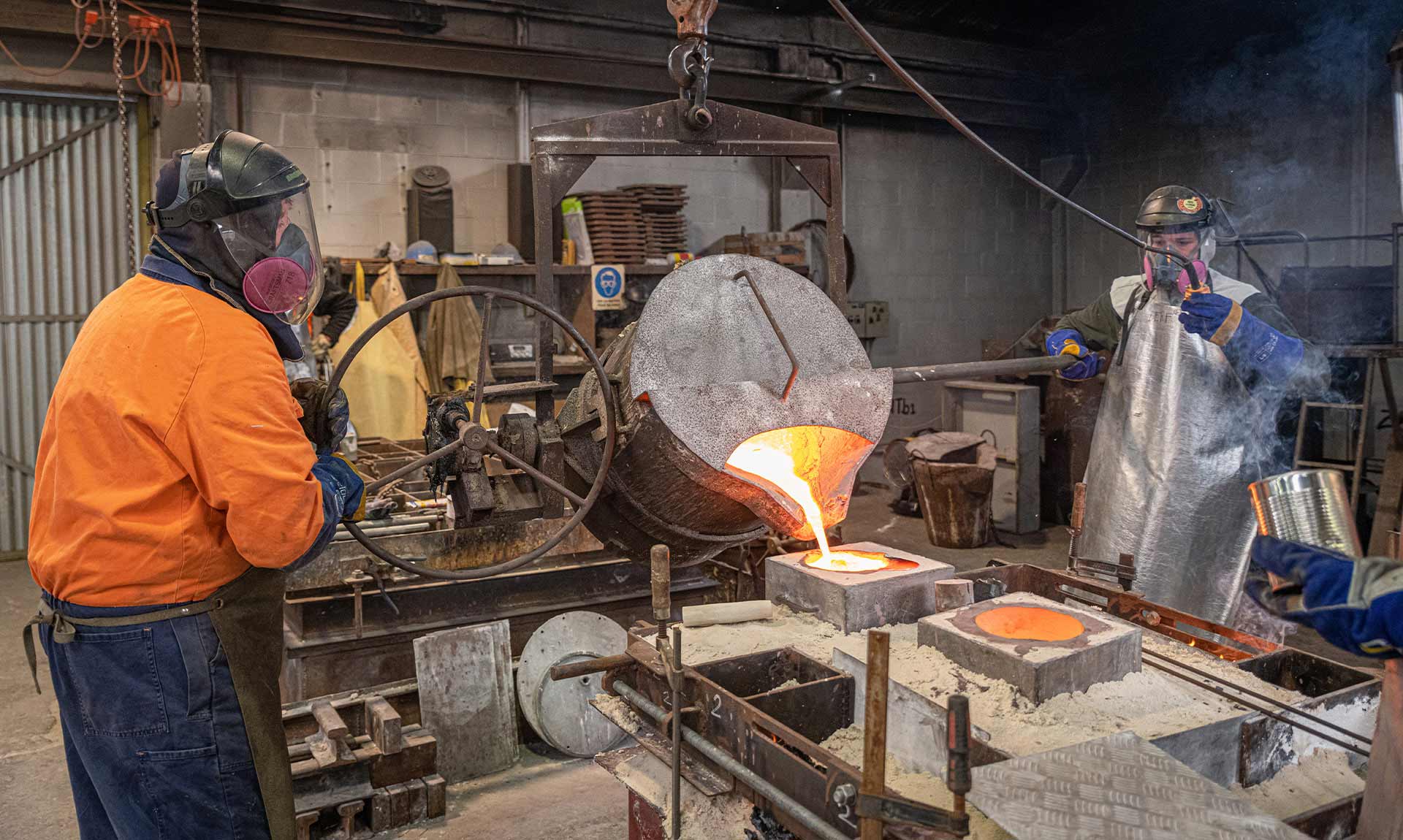 Pouring moulten bronze into the mould